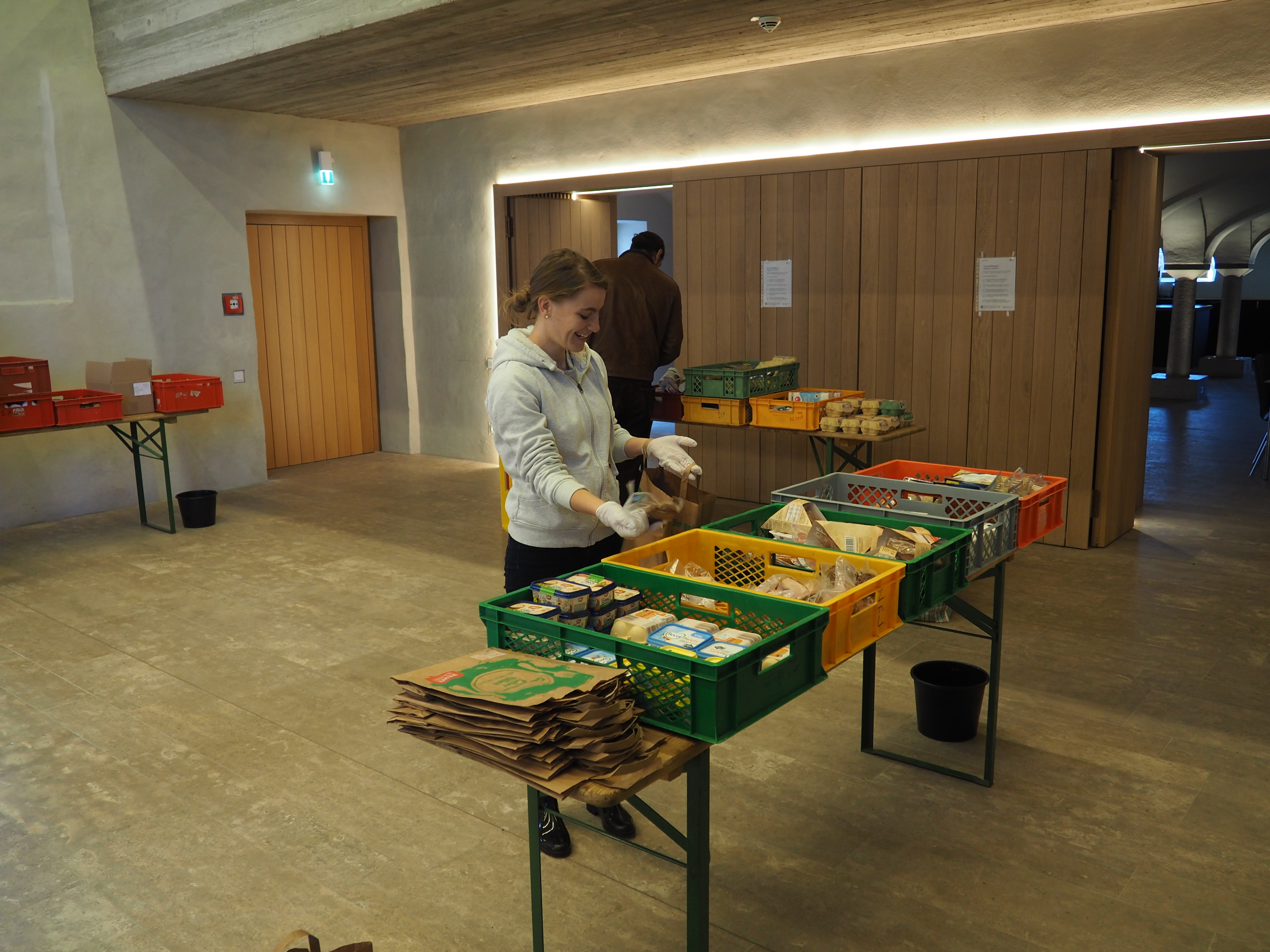 Sabrina Klebl, Riad Aufi und Doris Wittmann sortieren im Klostersaal Lebensmittel in die Ausgabetüten, Foto Michael Murner