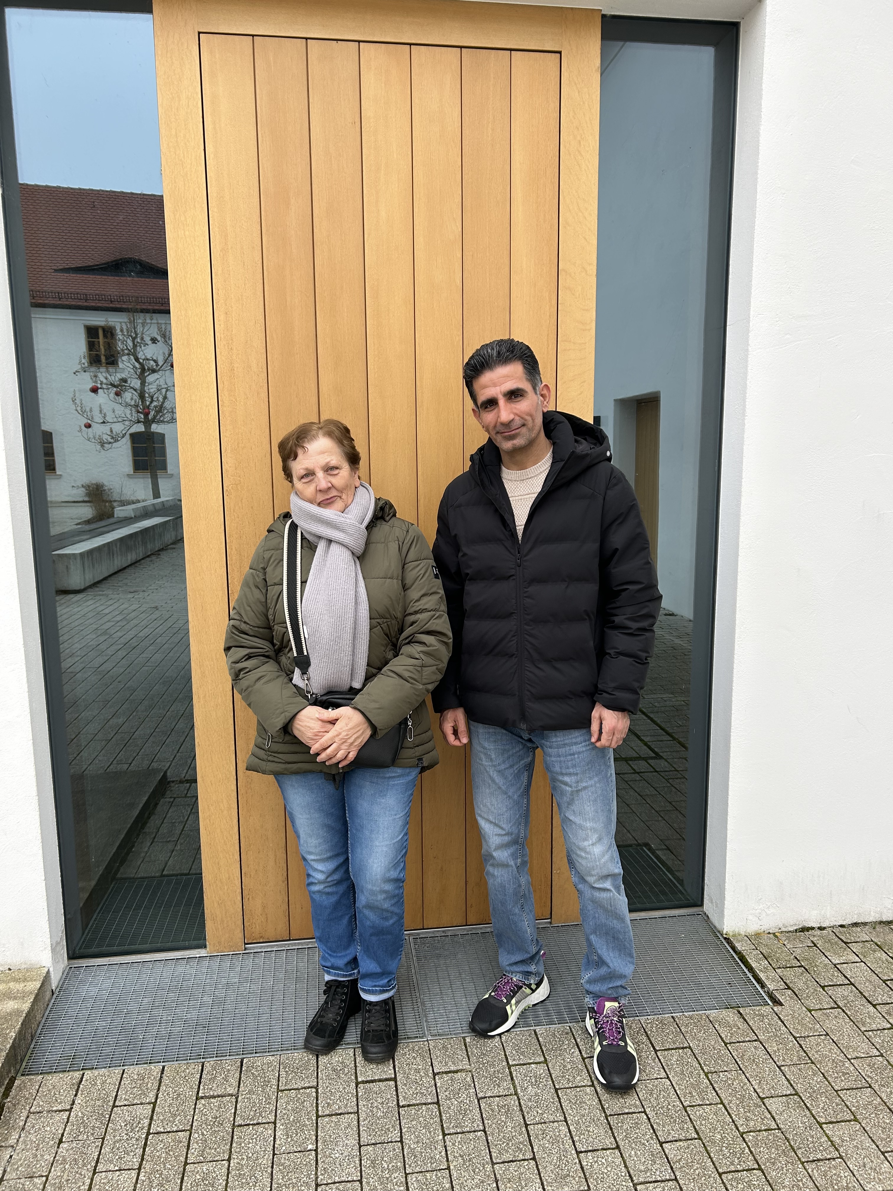Marianne Geitner und Aboozar Iranshahi stehen vor der Tür zum Klostersaal