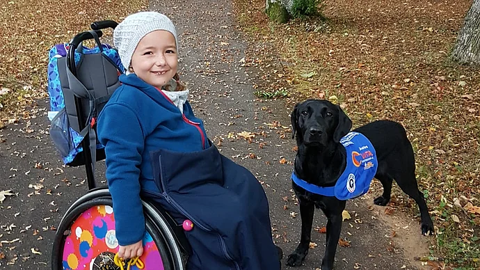 Kind im Rollstuhl mit Therapiehund, Foto Privat