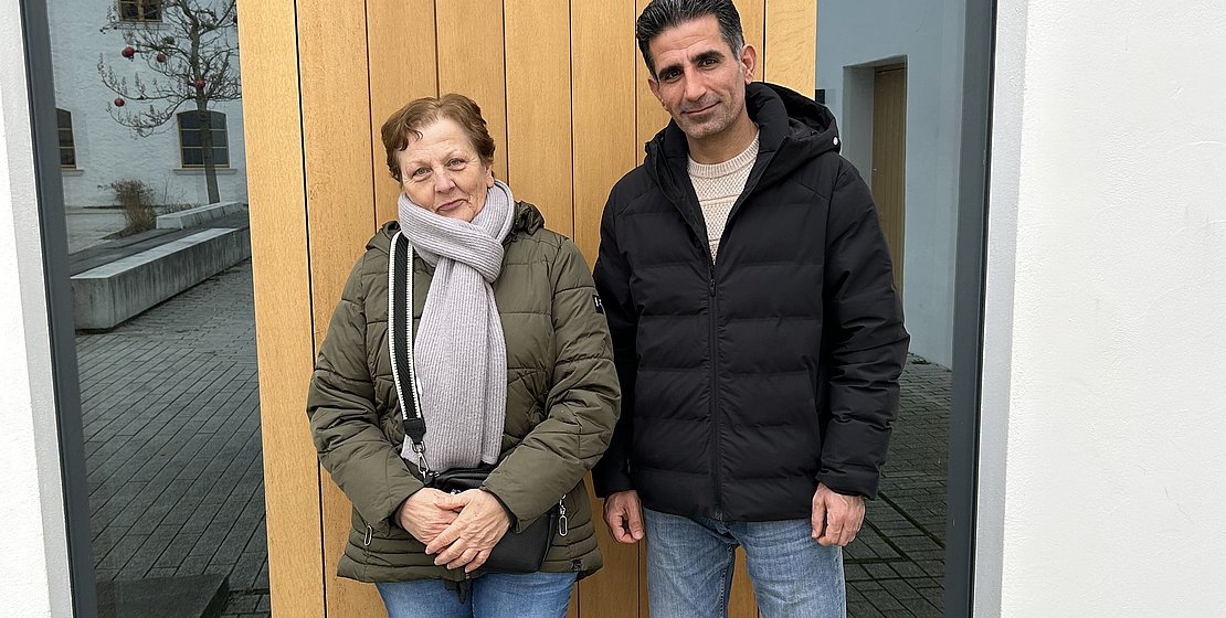 Marianne Geitner und Aboozar Iranshahi stehen vor der Tür zum Klostersaal