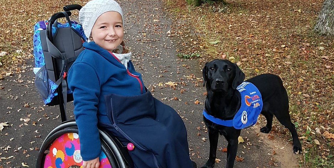 Kind im Rollstuhl mit Therapiehund, Foto Privat